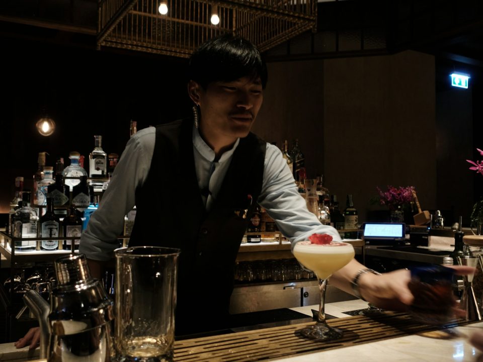 Barman préparant un cocktail dans un bar tamisé
