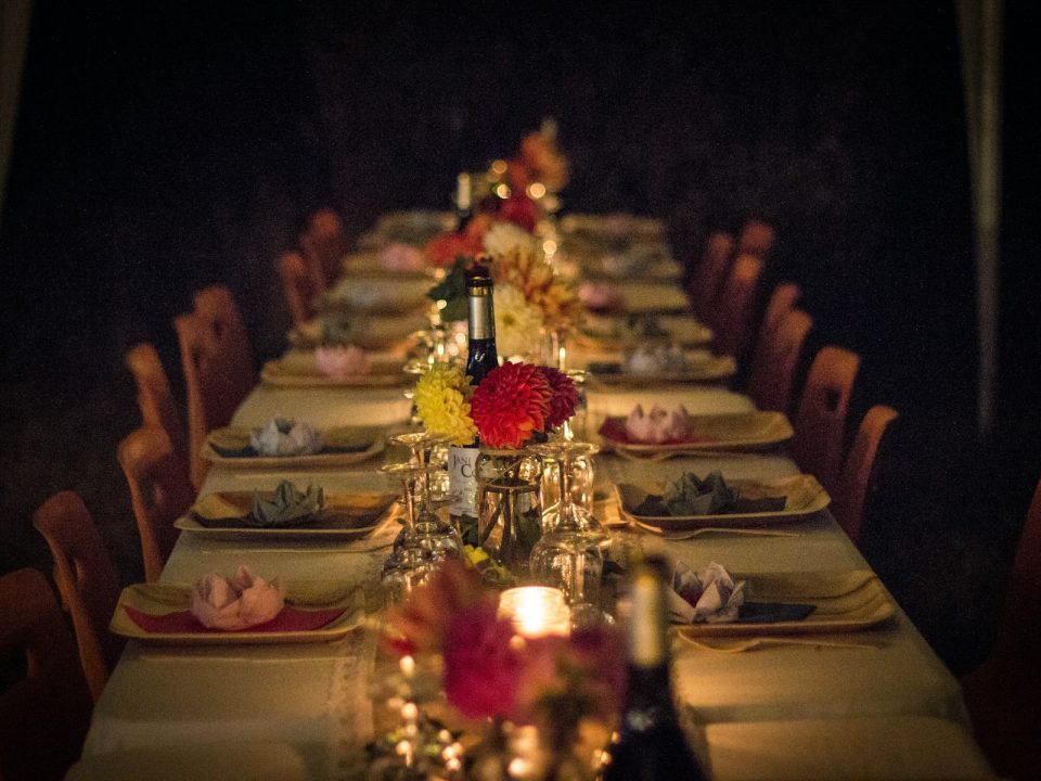 Longue table dressée aux bougies et aux fleurs rouges